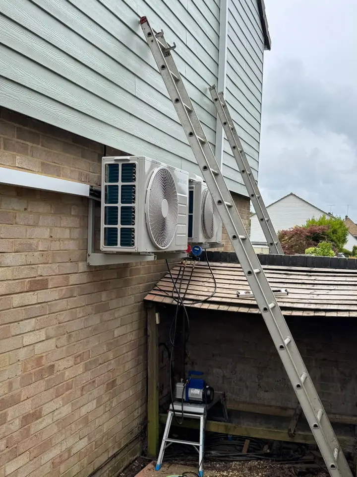 Two outdoor air conditioning units mounted on an exterior wall