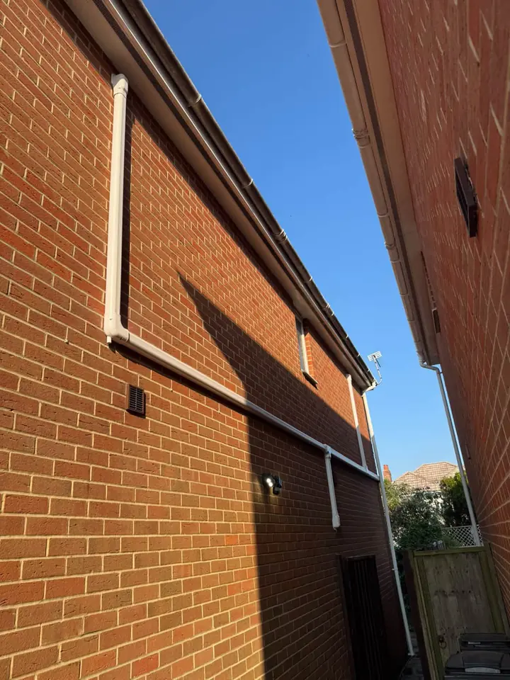 Air conditioning pipework installed neatly along an exterior brick wall