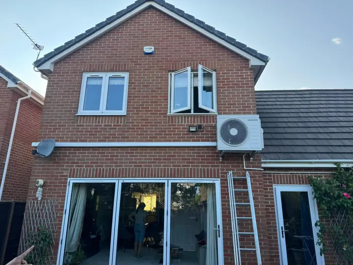 Completed outdoor air conditioning installation on a brick house