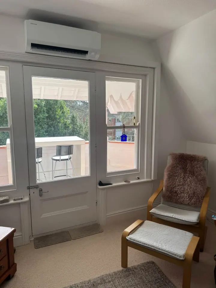 Wall-mounted indoor air conditioning unit above glazed doors